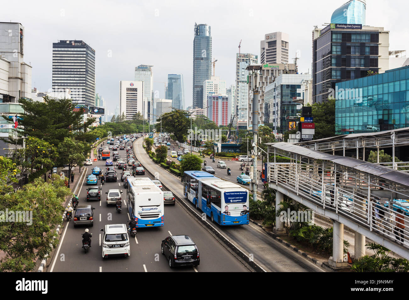 JAKARTA, INDONESIA - MAY 30, 2017: A transjakarta bus uses its separtef traffic lane on Sudirman avenue to beat the heavy traffic in Jakarta business  Stock Photo