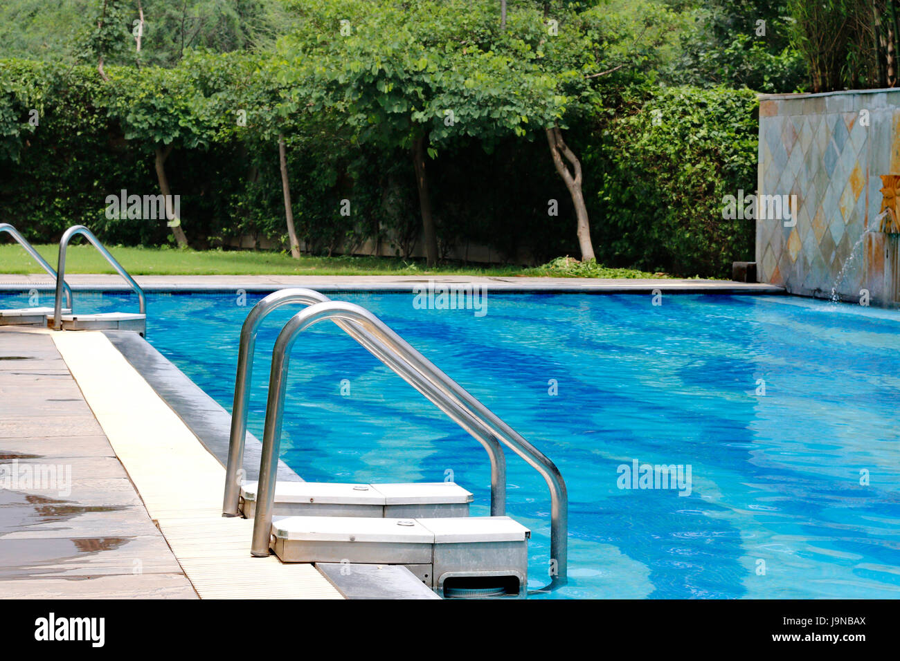 side view of a swimming pool with grass in background Stock Photo