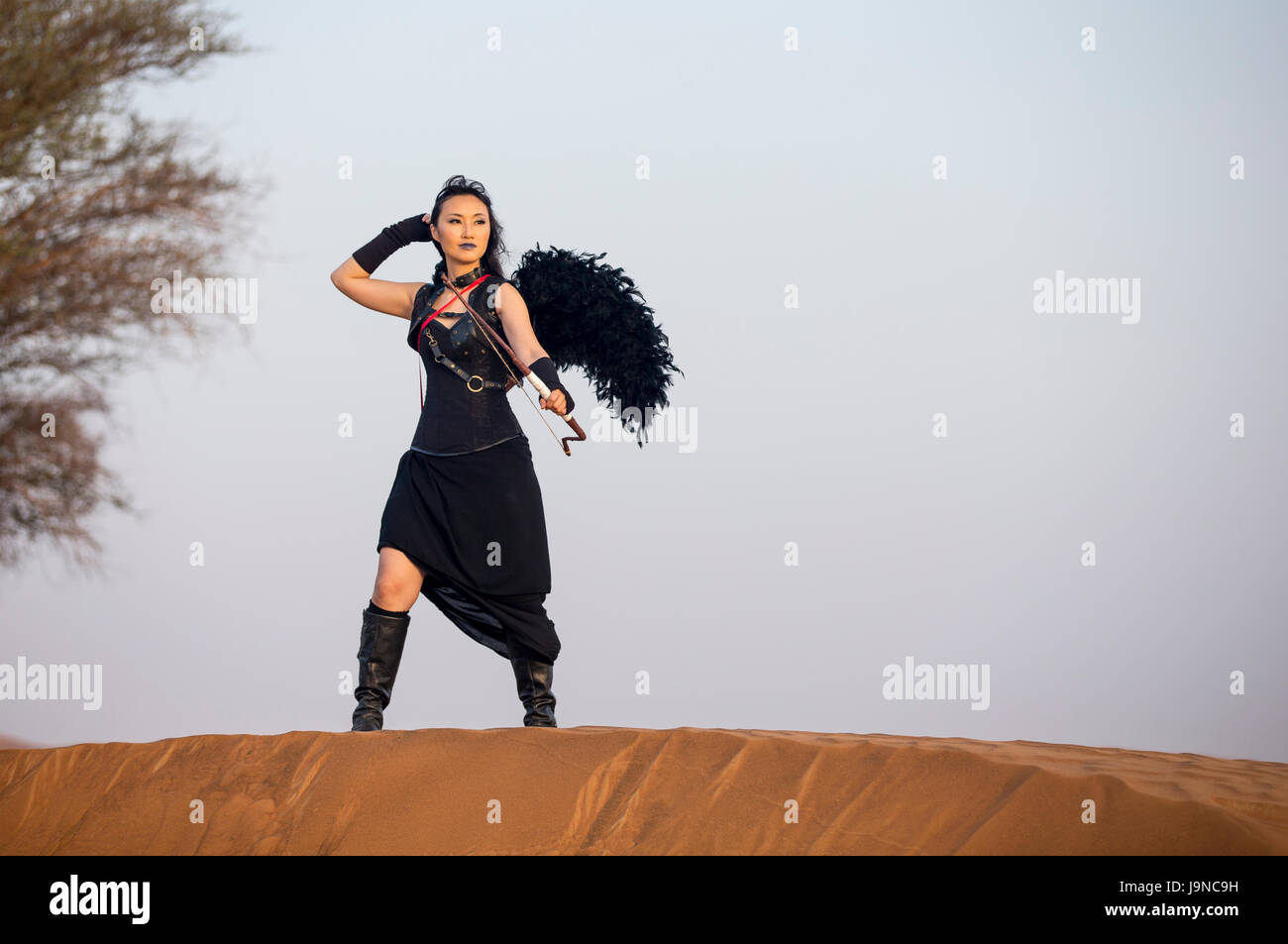 young woman with a bow and arrors in a desert near Dubai Stock Photo