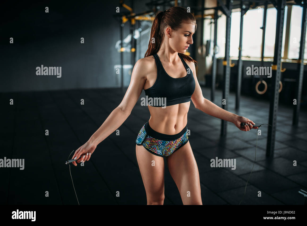 Female athlete exercise with a jump rope in sport gym. Active woman workout  in fitness club Stock Photo - Alamy