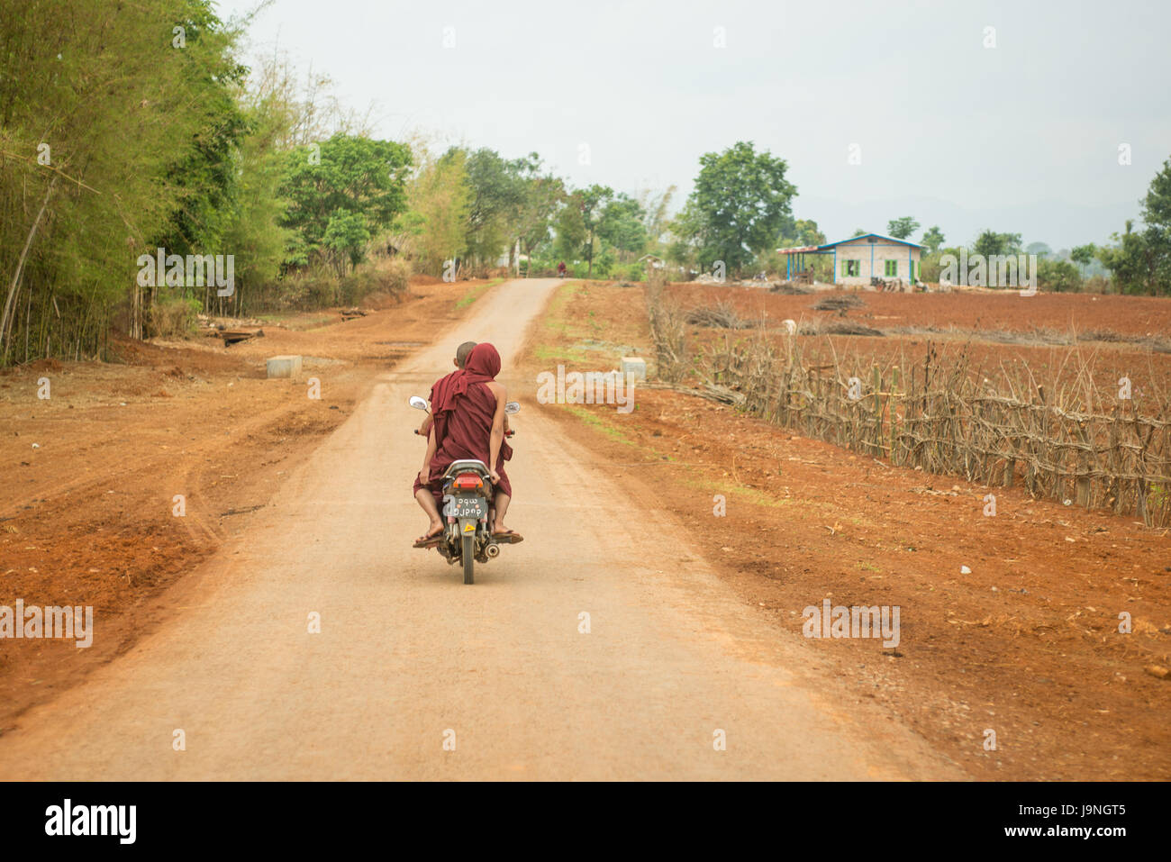 A couple riding a motor scooter near Pindaya, Myanmar. Stock Photo