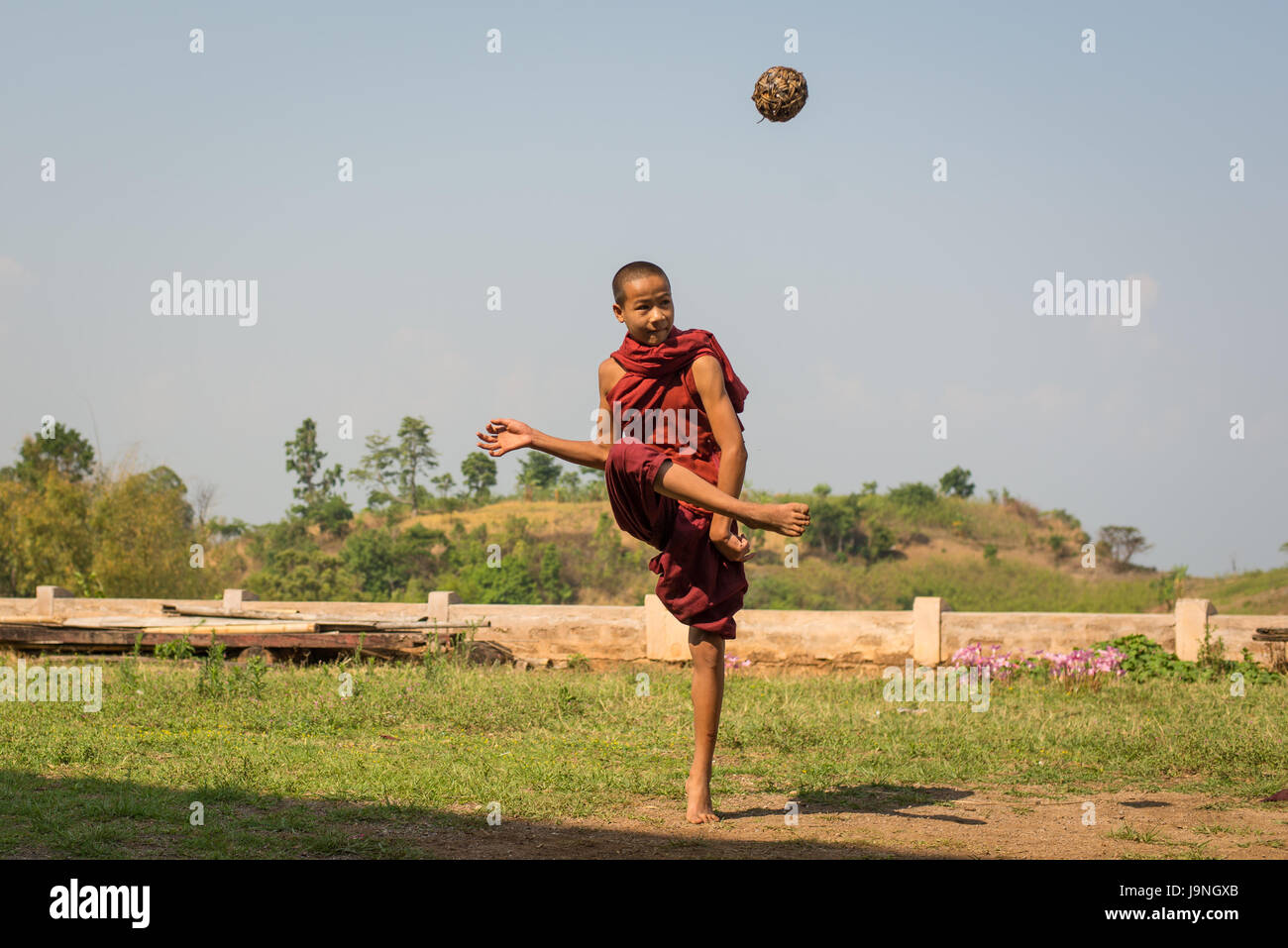 Young man kicking a wicker ball in a small village near Inle Lake, Myanmar. Stock Photo