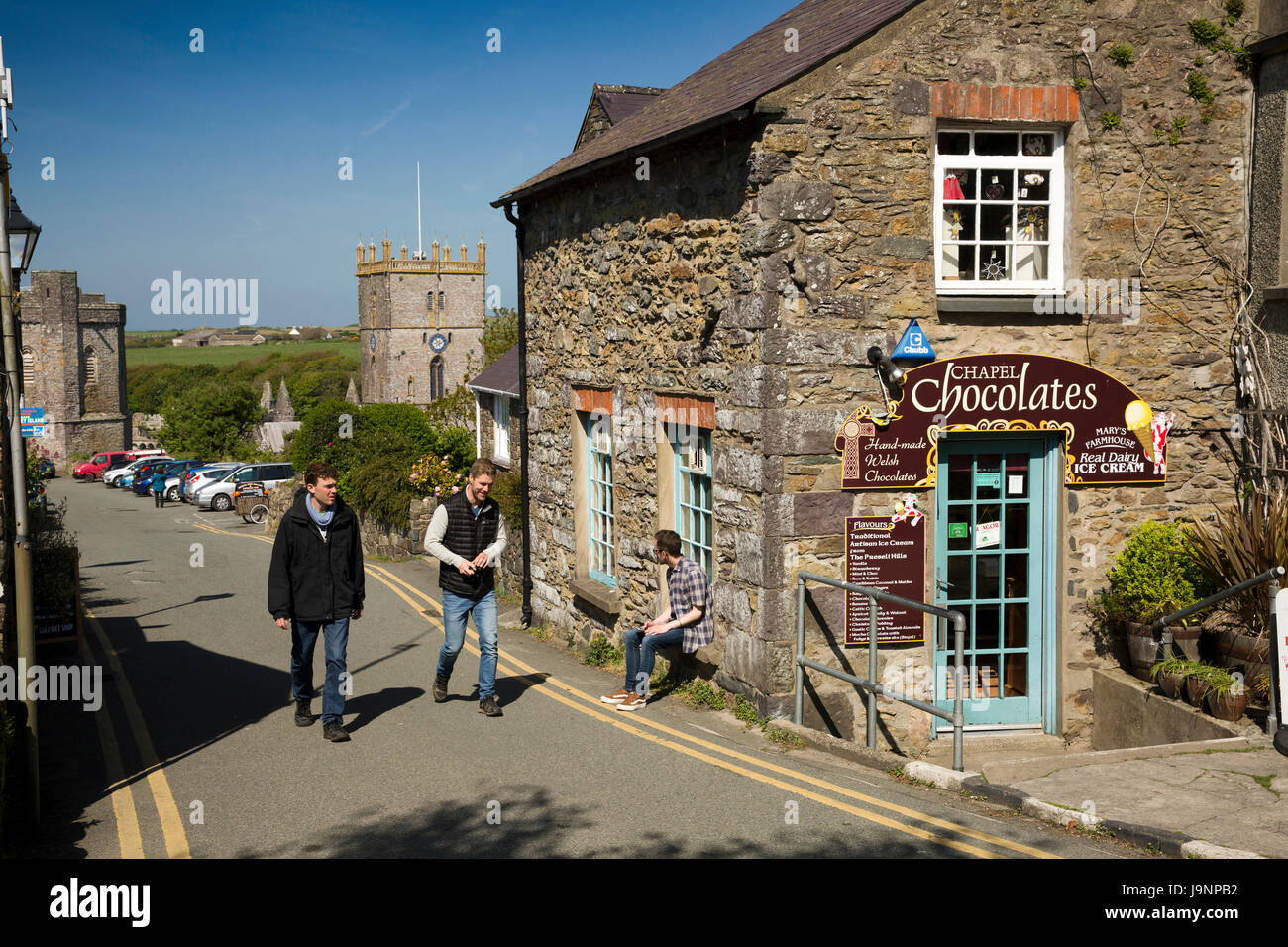 UK, Wales, Pembrokeshire, St Davids, The Pebbles, visitors walking past Chapel Chocolates sweet shop above the Cathedral Stock Photo