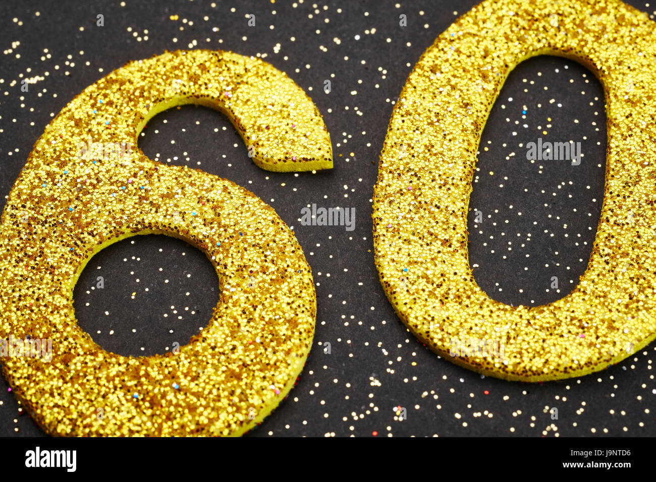 Number sixty golden color over a black background. Anniversary. Horizontal Stock Photo