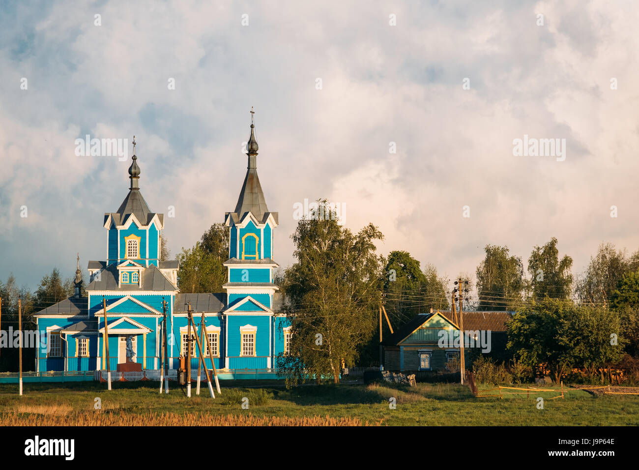 Krasnyy Partizan, Dobrush District, Gomel Region, Belarus. Old Wooden Orthodox Church of the Nativity of the Virgin Mary At Sunset In Village Stock Photo