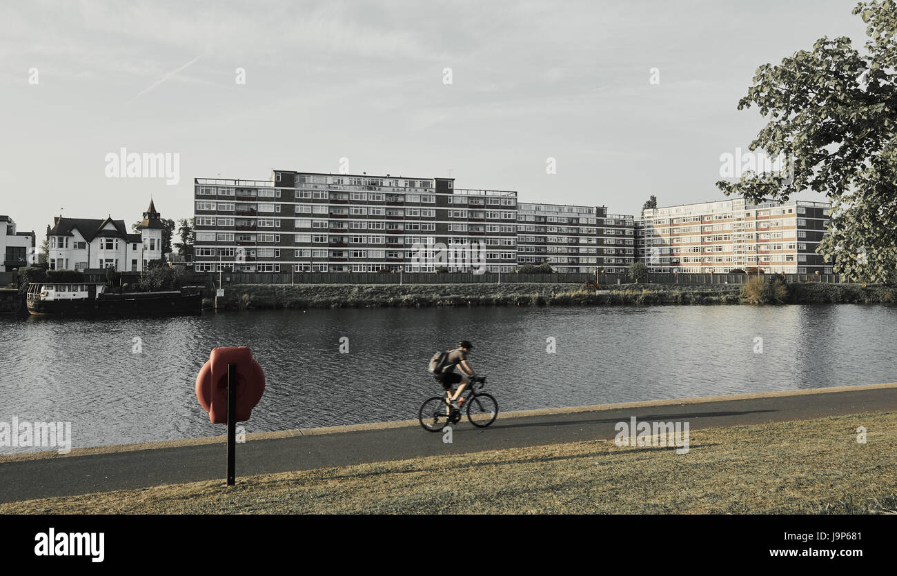 Apartment block and cyclist by the river Trent, Nottingham