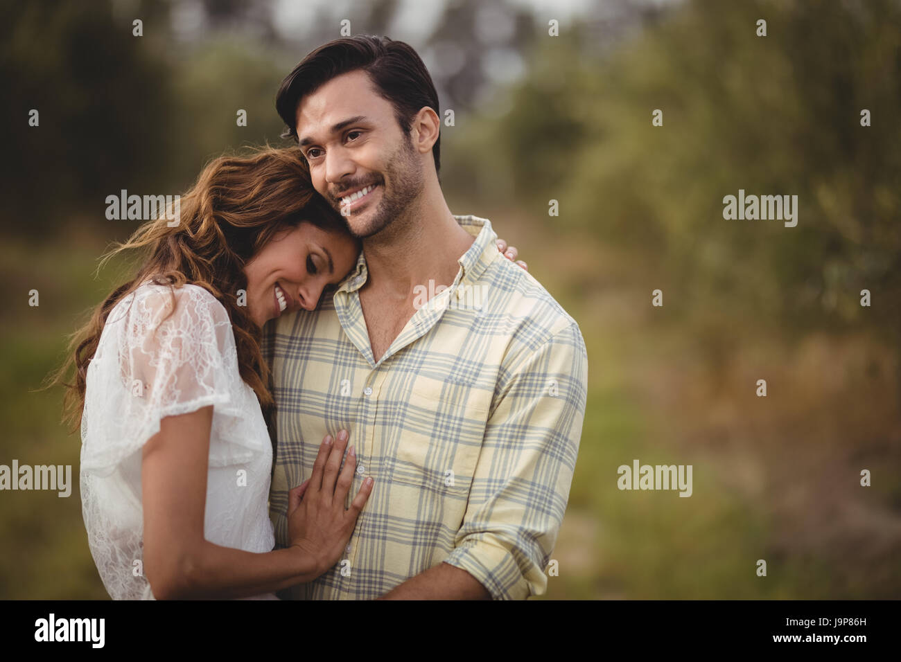 Smiling young couple embracing at olive farm Stock Photo - Alamy