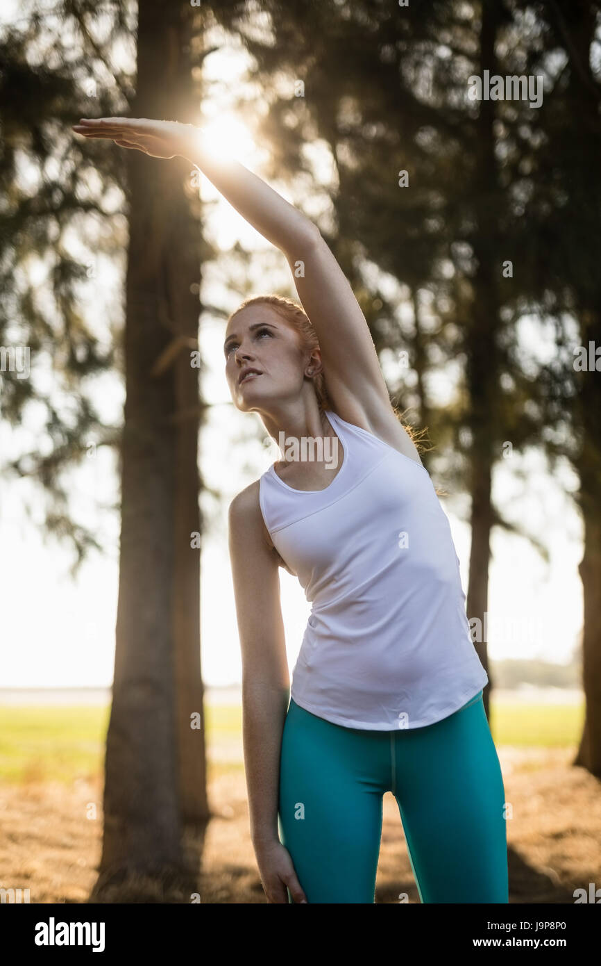 Low angle view of young woman exercising on field at farm Stock Photo