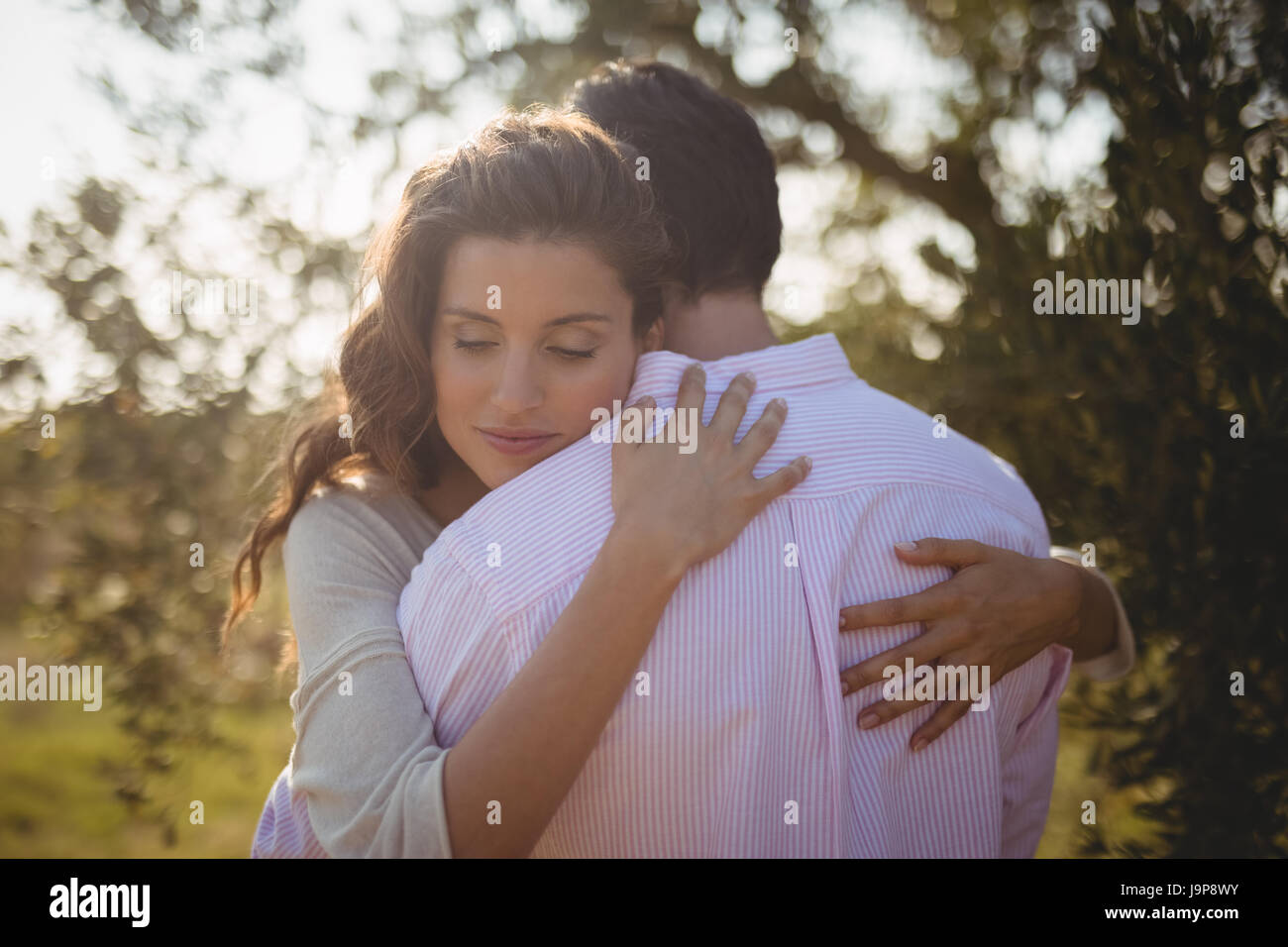 Young woman hugging boyfriend at olive farm Stock Photo - Alamy