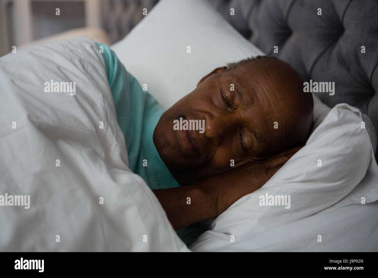 Senior man sleeping on bed at home Stock Photo - Alamy