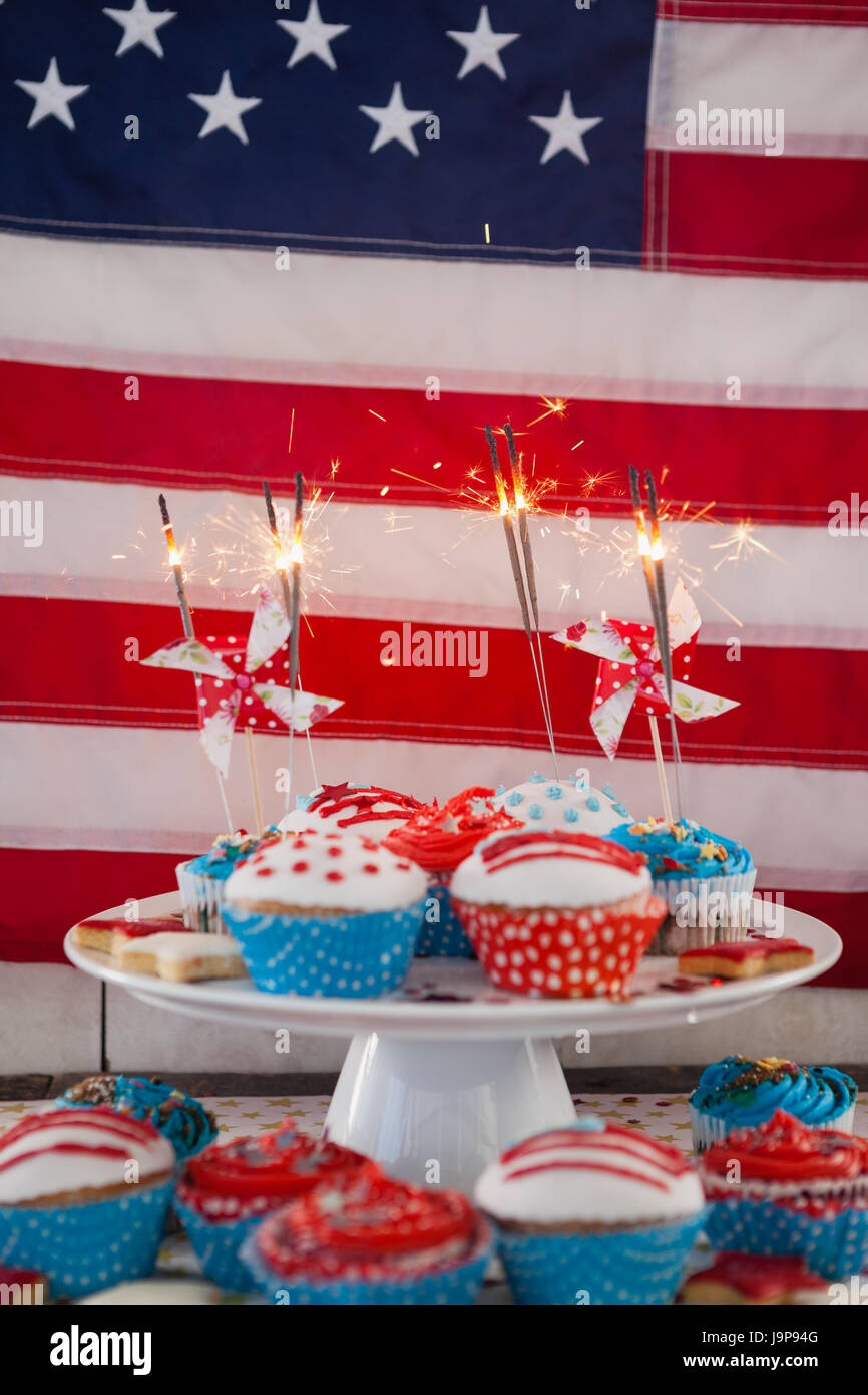 Burning sparkler on decorated cupcakes against American flag Stock ...