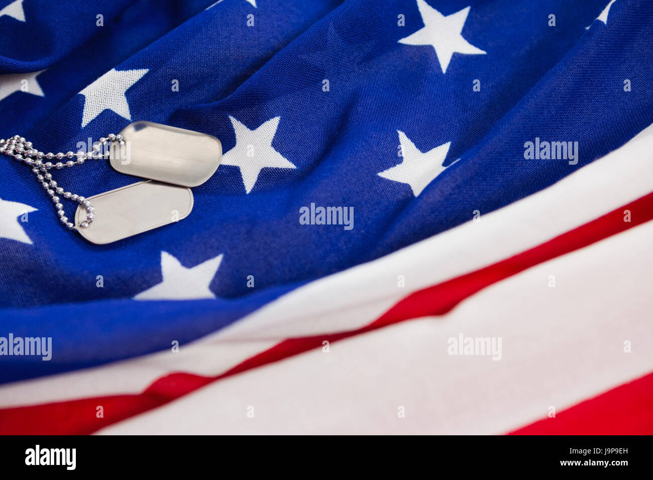 Close-up of dog tags chain on an American flag Stock Photo - Alamy