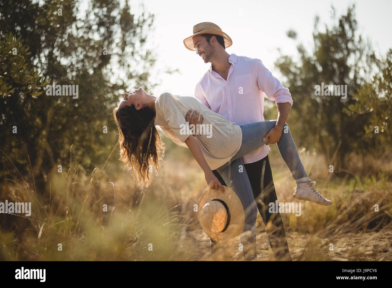 Happy young couple posing together at olive farm Stock Photo - Alamy