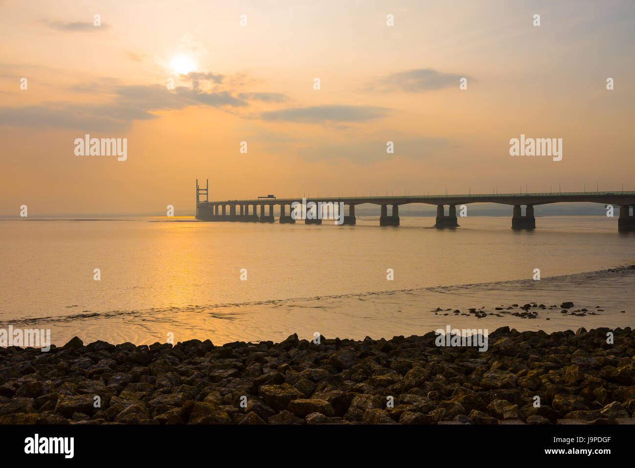 The Prince of Wales Bridge (Second Severn Crossing) during a hazy sunset over the Severn Estuary viewed from Severn Beach, Gloucestershire, England. Stock Photo