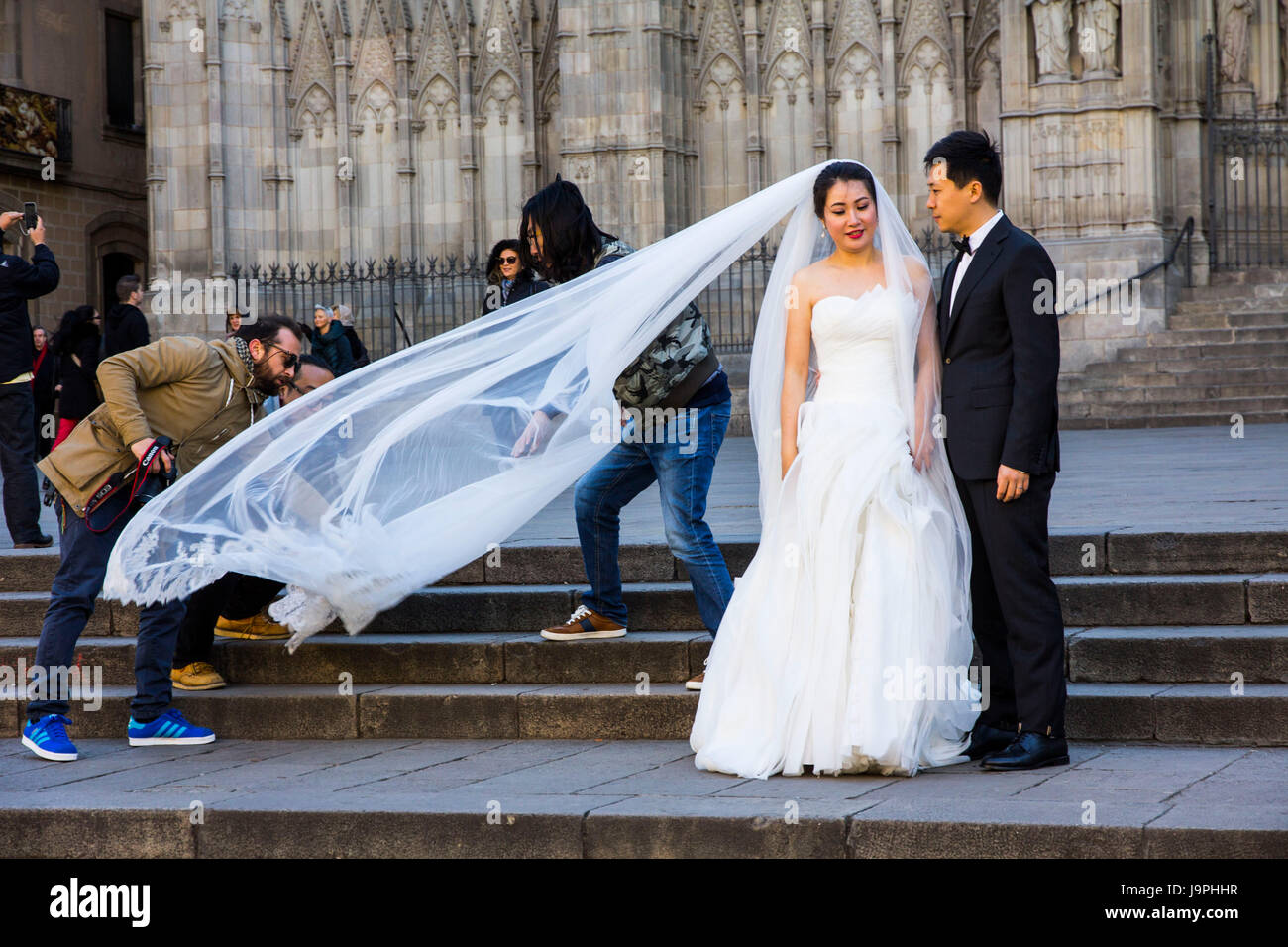 An Asian couple poses for wedding photos in front of Barcelona Cathedral, Barcelona, Spain. Stock Photo