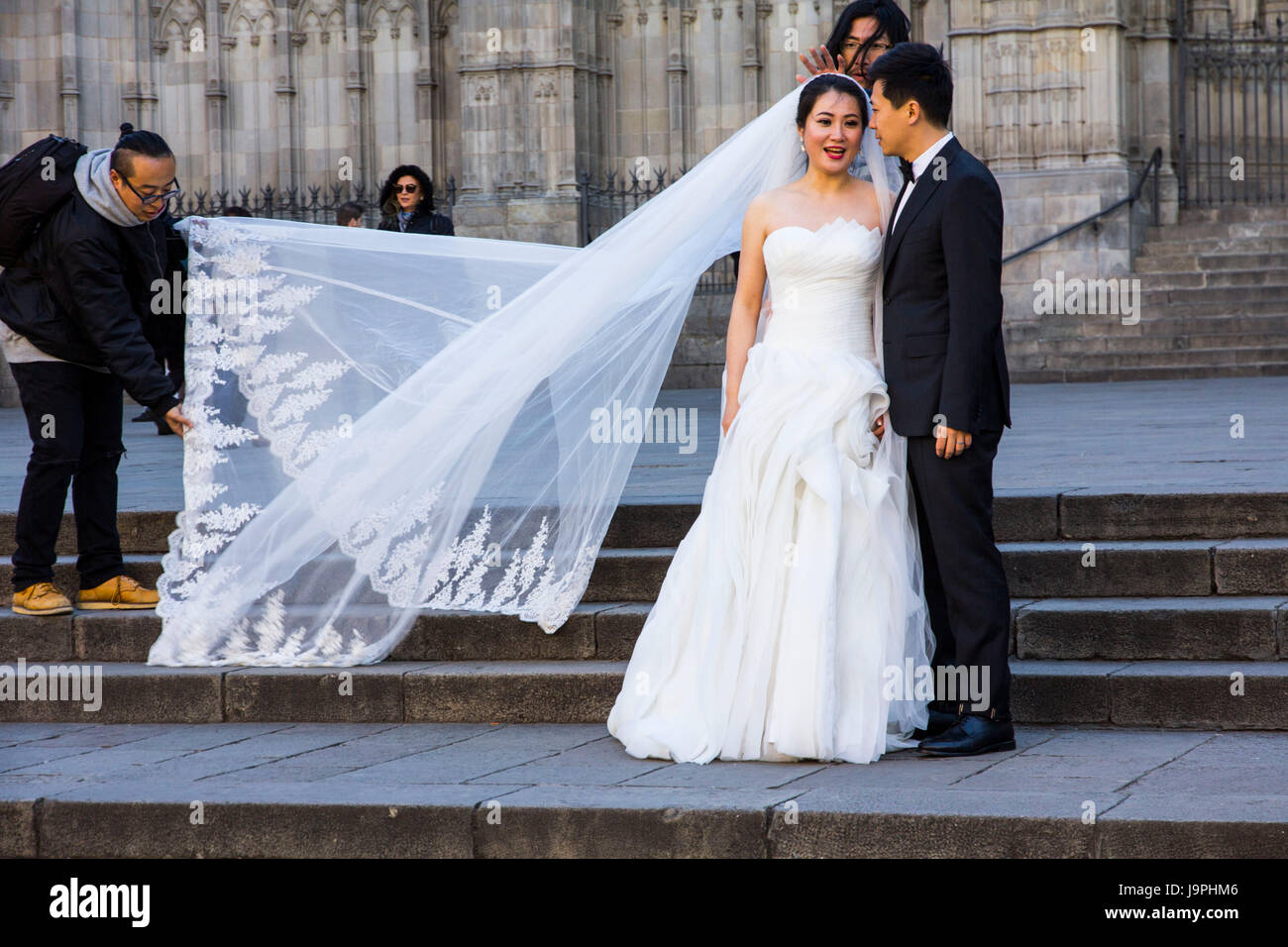 An Asian couple poses for wedding photos in front of Barcelona Cathedral, Barcelona, Spain. Stock Photo