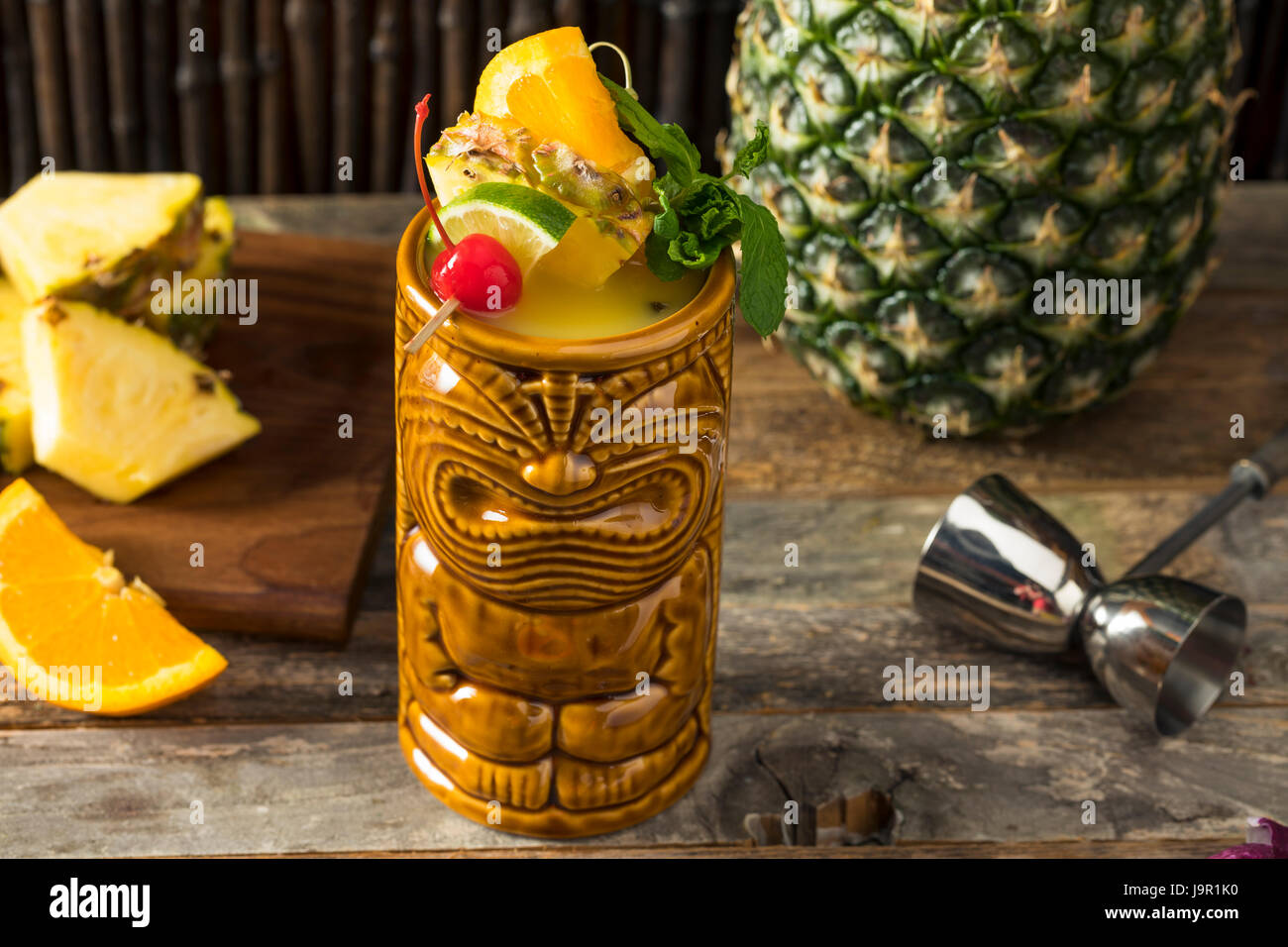 Refreshing Cold Tiki Drink Cocktails with Pineapple Cherry Orange Garnishes Stock Photo