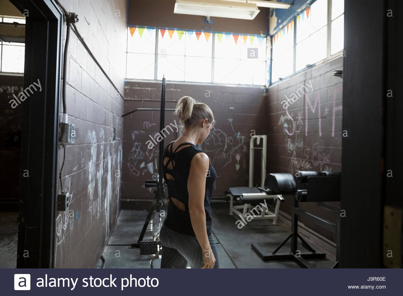 Fit woman weightlifting in gritty gym Stock Photo