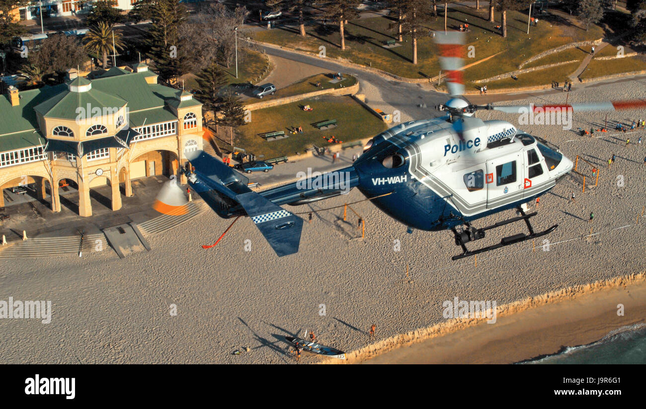 Western Australia Police Air Wing BK117 helicopter, over Cottesloe Beach in Perth. Stock Photo
