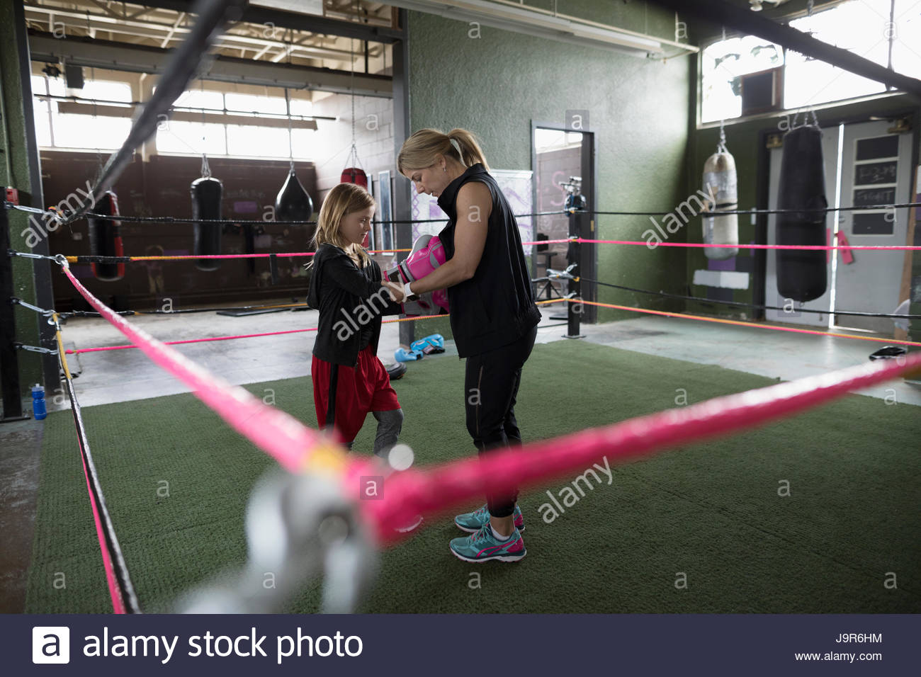 Mother boxer teaching daughter boxing in boxing ring at gym Stock Photo