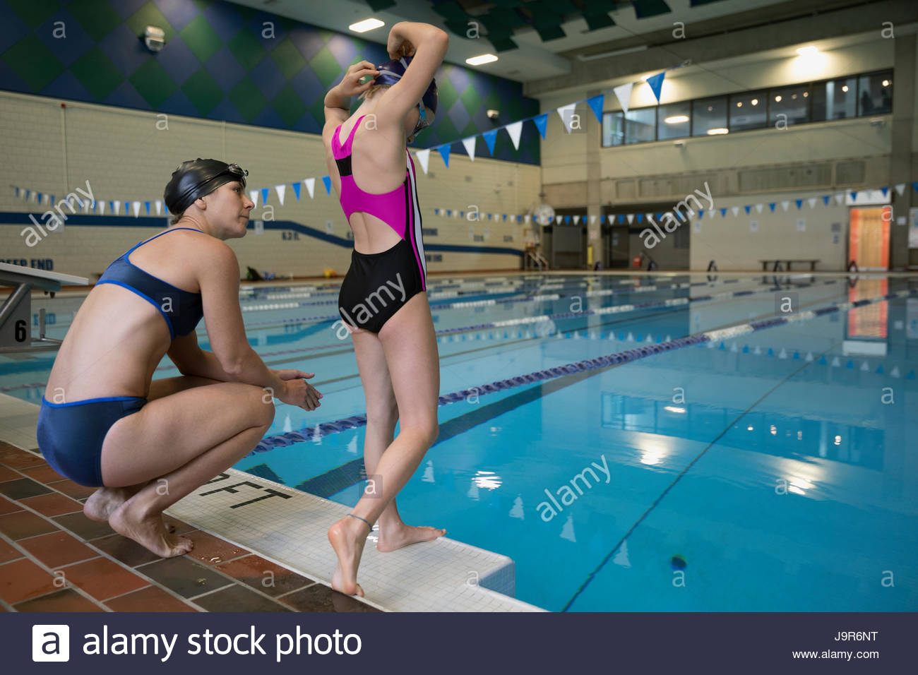Mother coaching daughter swimmer at swimming pool Stock Photo
