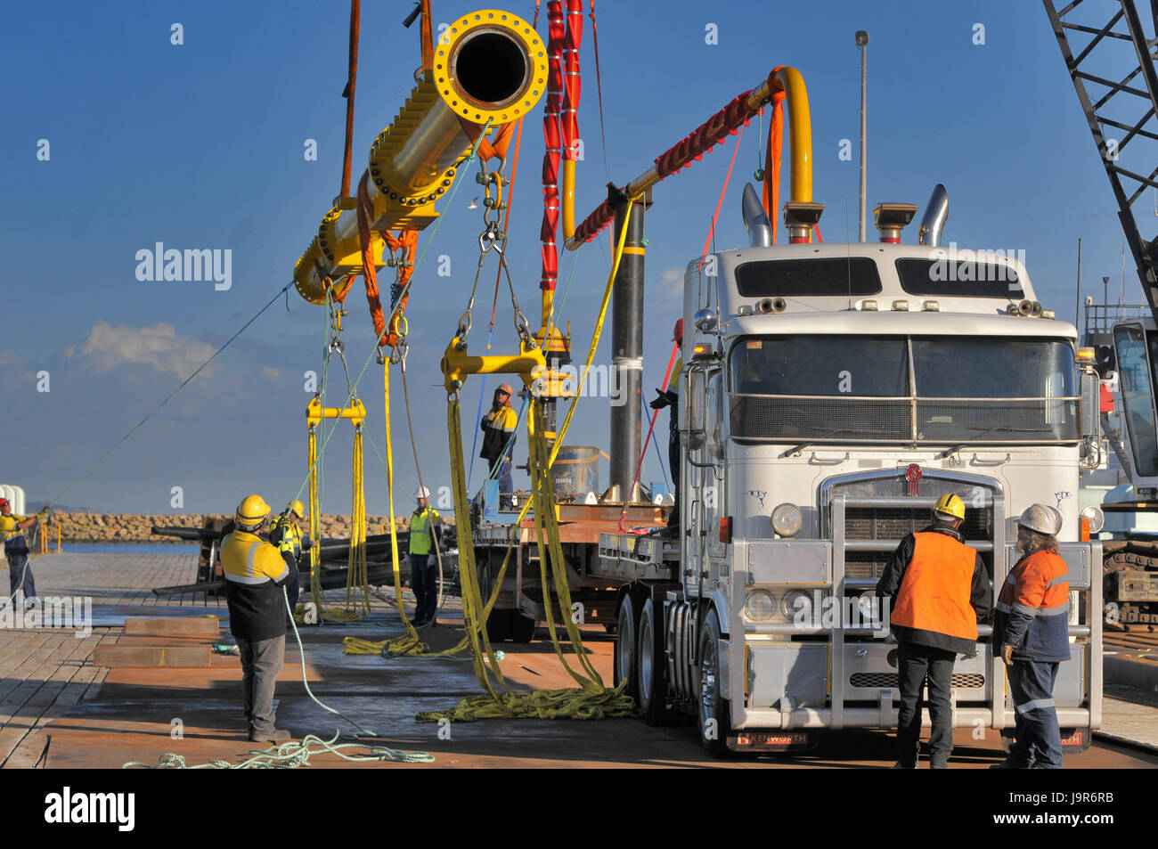 Oil platform pipe spool being loaded onto a transporter. Stock Photo