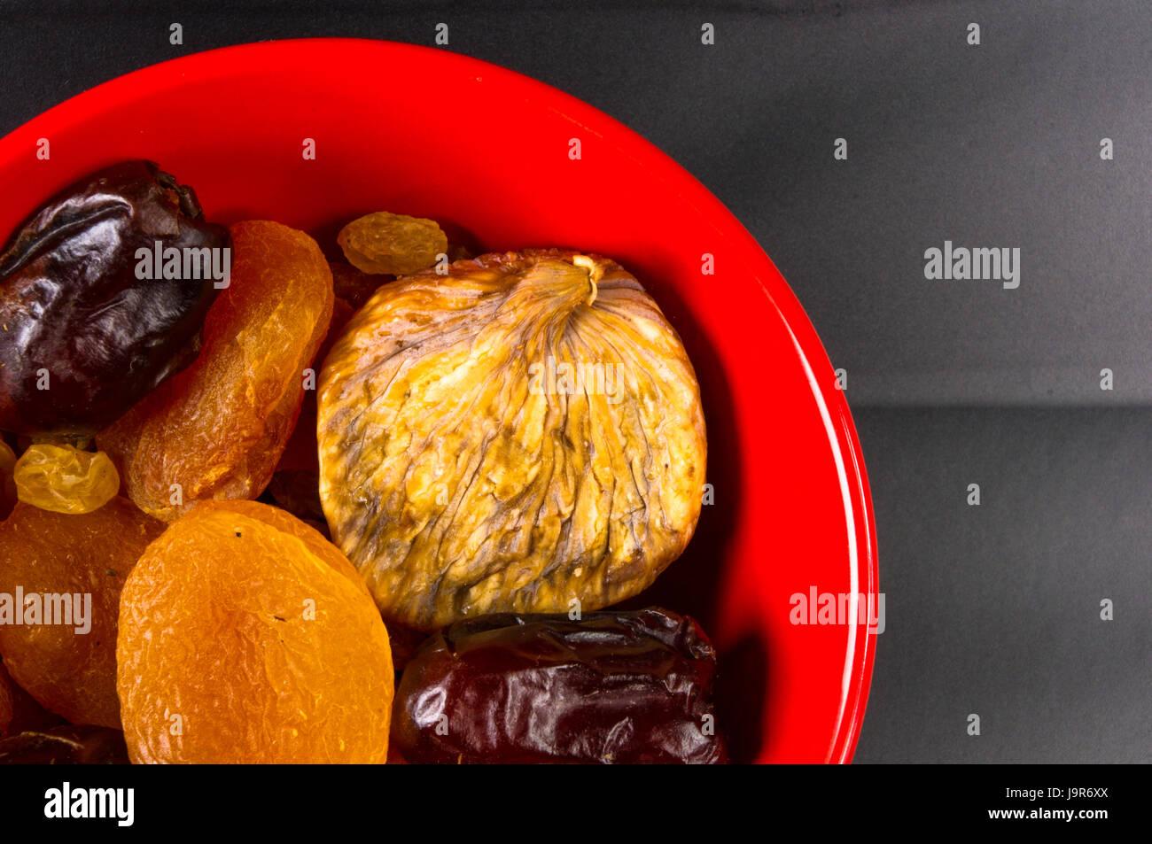 various dried fruits on the black background Stock Photo - Alamy