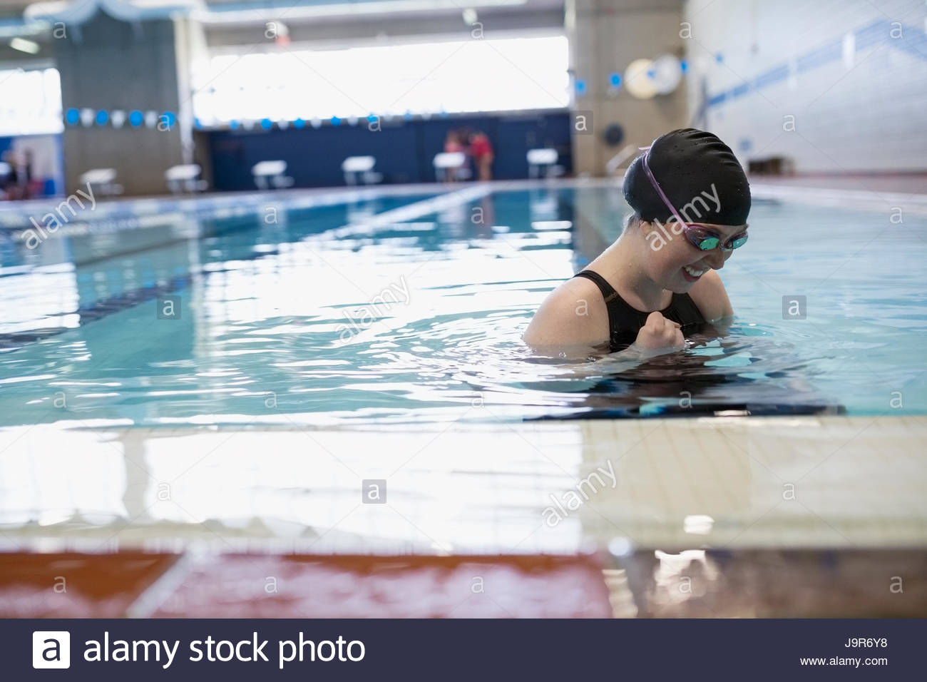 Smiling young woman swimmer in swimming pool Stock Photo