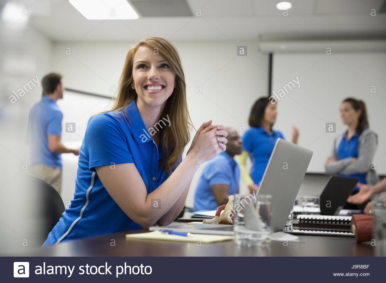 Smiling focused female physiotherapist with laptop training in conference room meeting Stock Photo