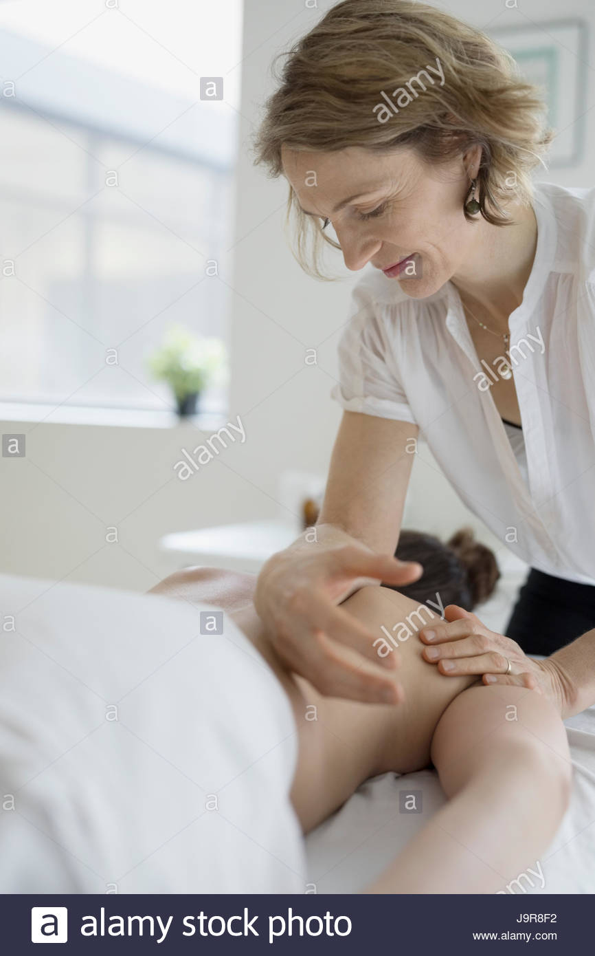 Female masseuse massaging woman on spa massage table Stock Photo