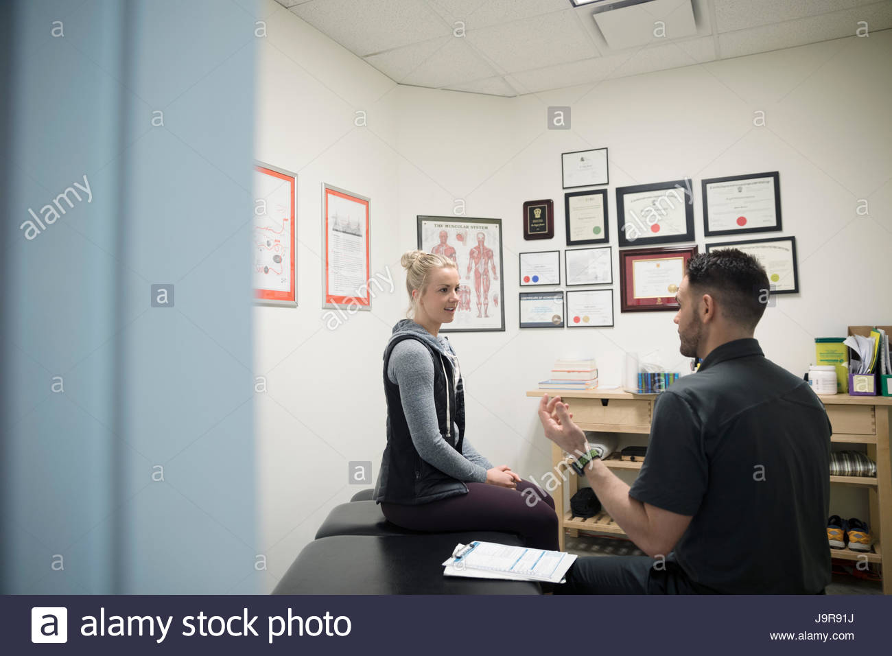 Male physiotherapist talking to female client in office Stock Photo