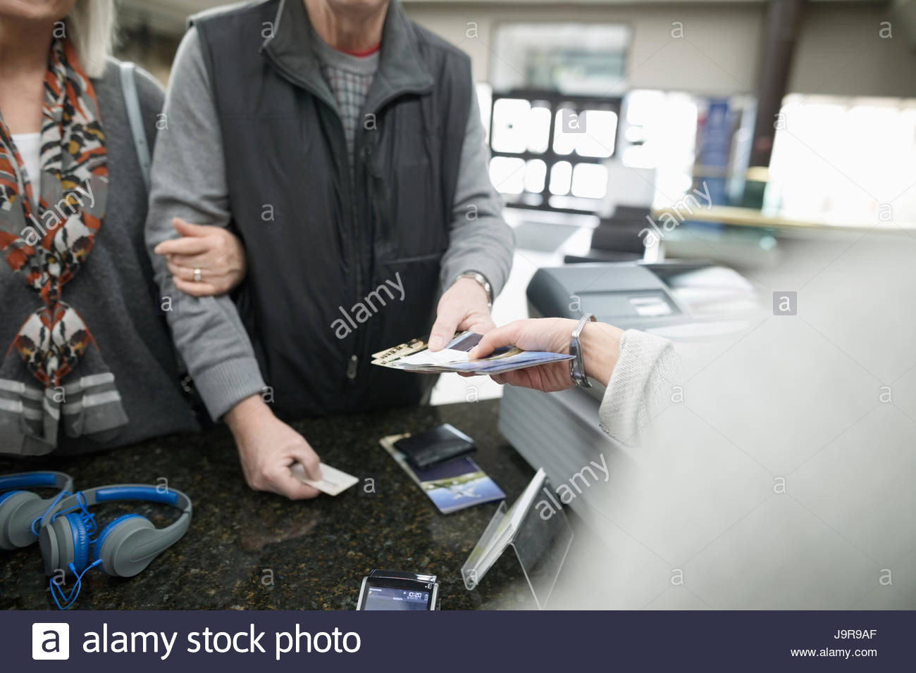 Cashier giving tickets to couple in museum Stock Photo