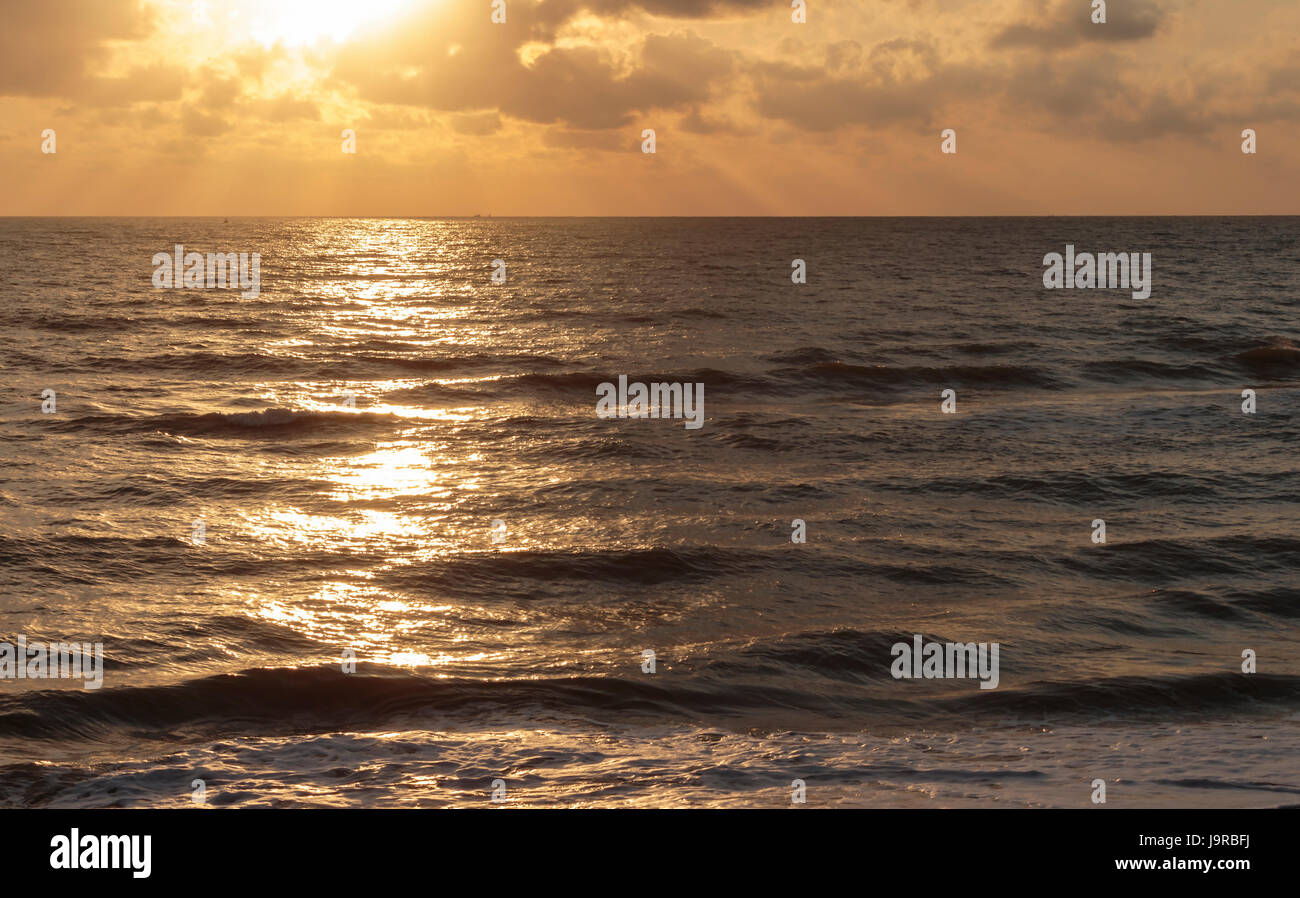 Light from the sunrise is a beautiful golden reflection of the sea ...
