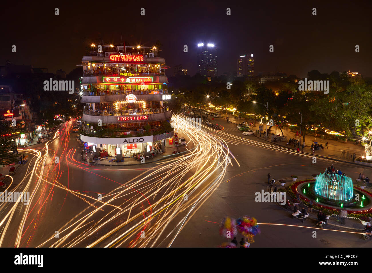 Bars, restaurants and lights from traffic at busy intersection by Hoan Kiem Lake and Old Quarter, Hanoi, Vietnam Stock Photo