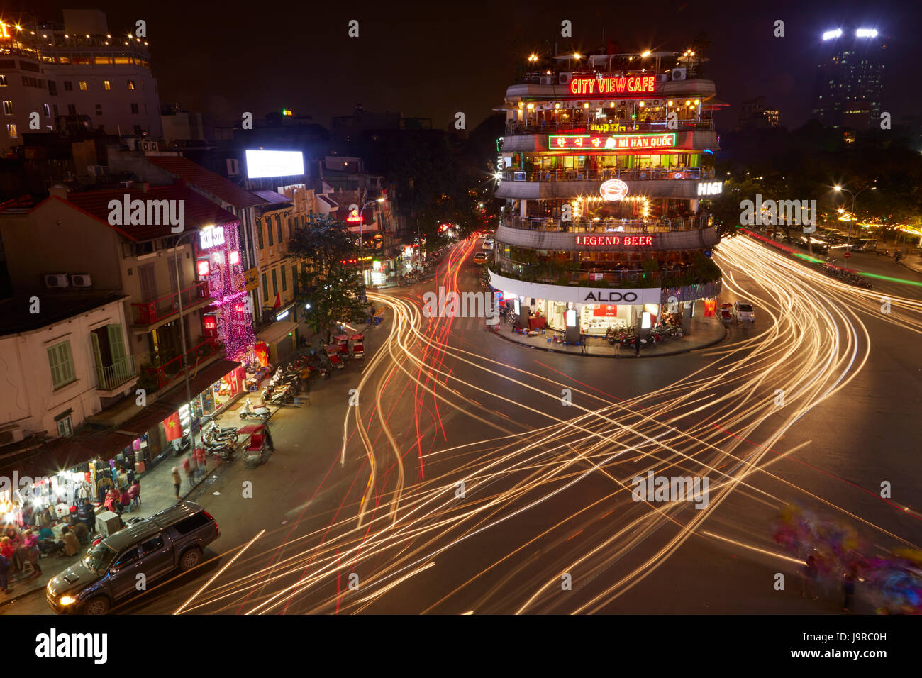 Bars, restaurants and lights from traffic at busy intersection by Hoan Kiem Lake and Old Quarter, Hanoi, Vietnam Stock Photo