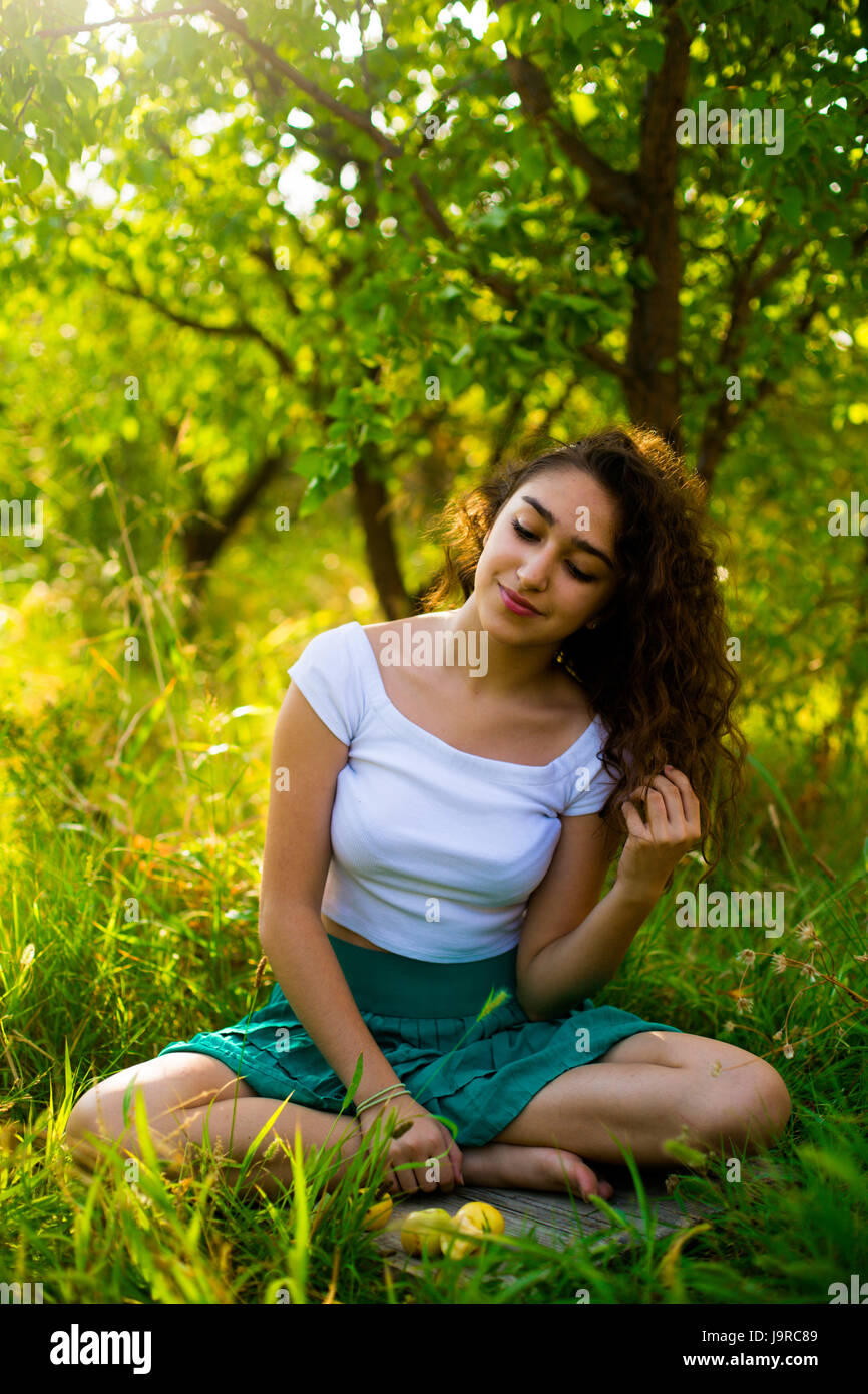 Young girl in green garden in the morning Stock Photo