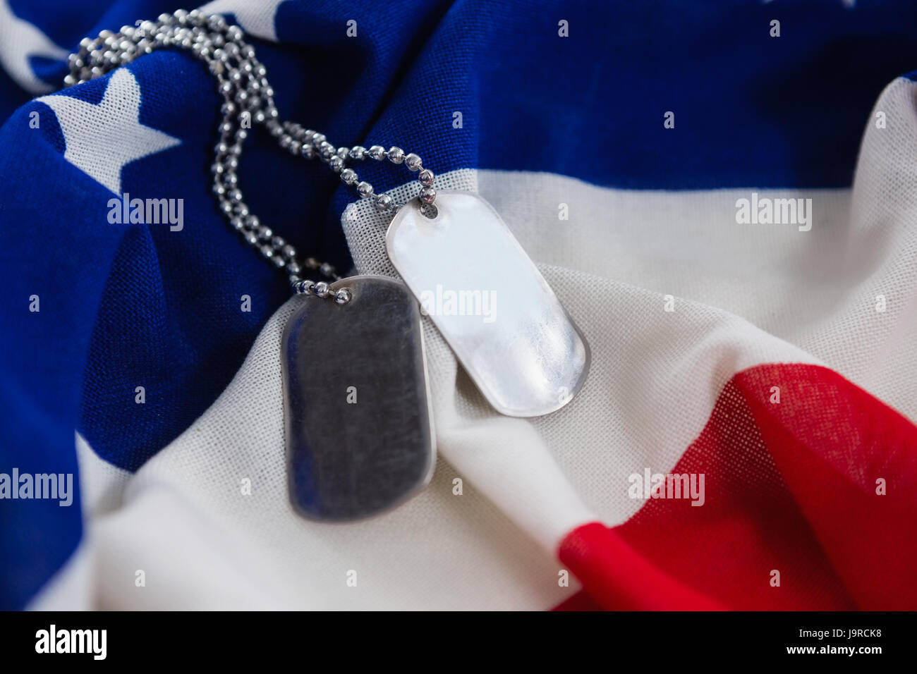 Close-up of dog tags chain on an American flag Stock Photo - Alamy