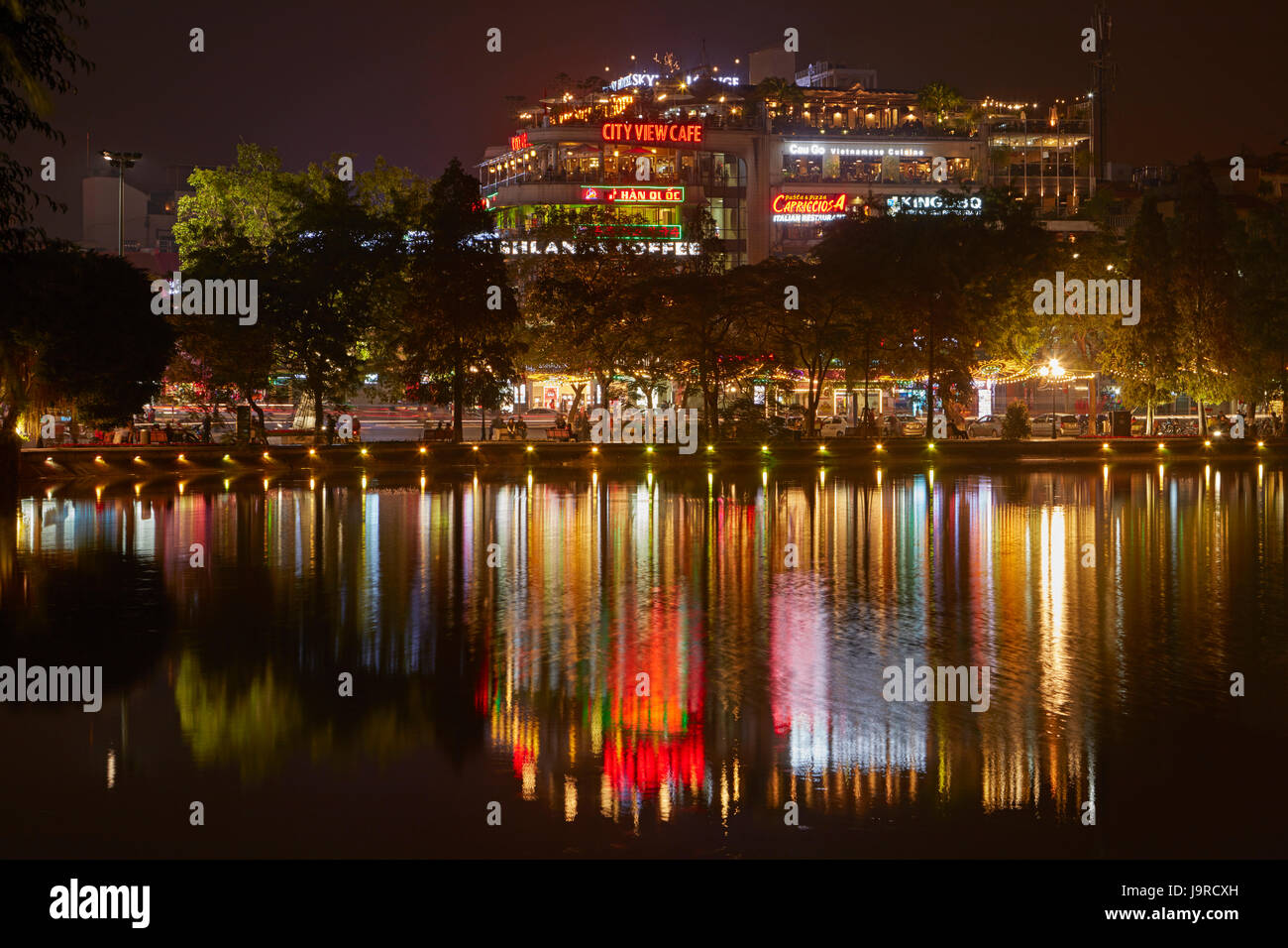 Restaurants and bars reflected in Hoan Kiem Lake at night, Hanoi, Vietnam Stock Photo