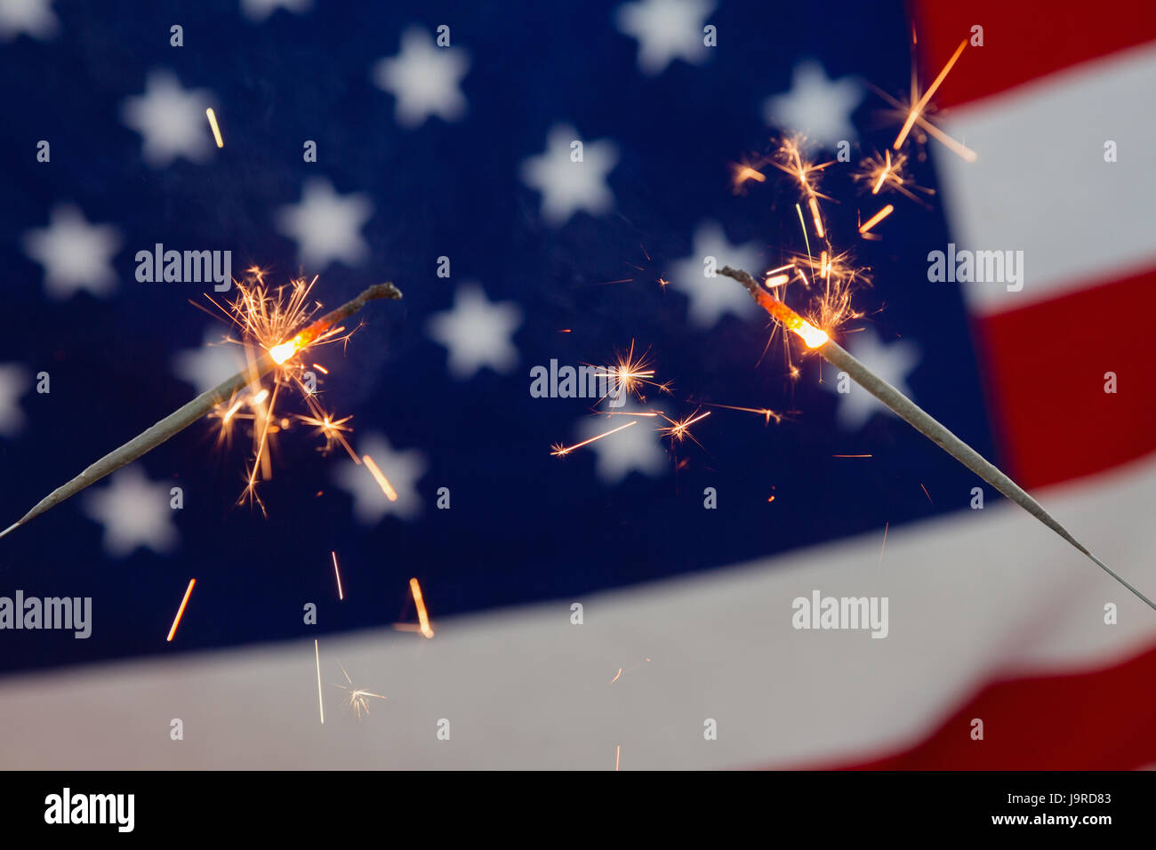 Close-up of sparklers burning against American flag background Stock ...