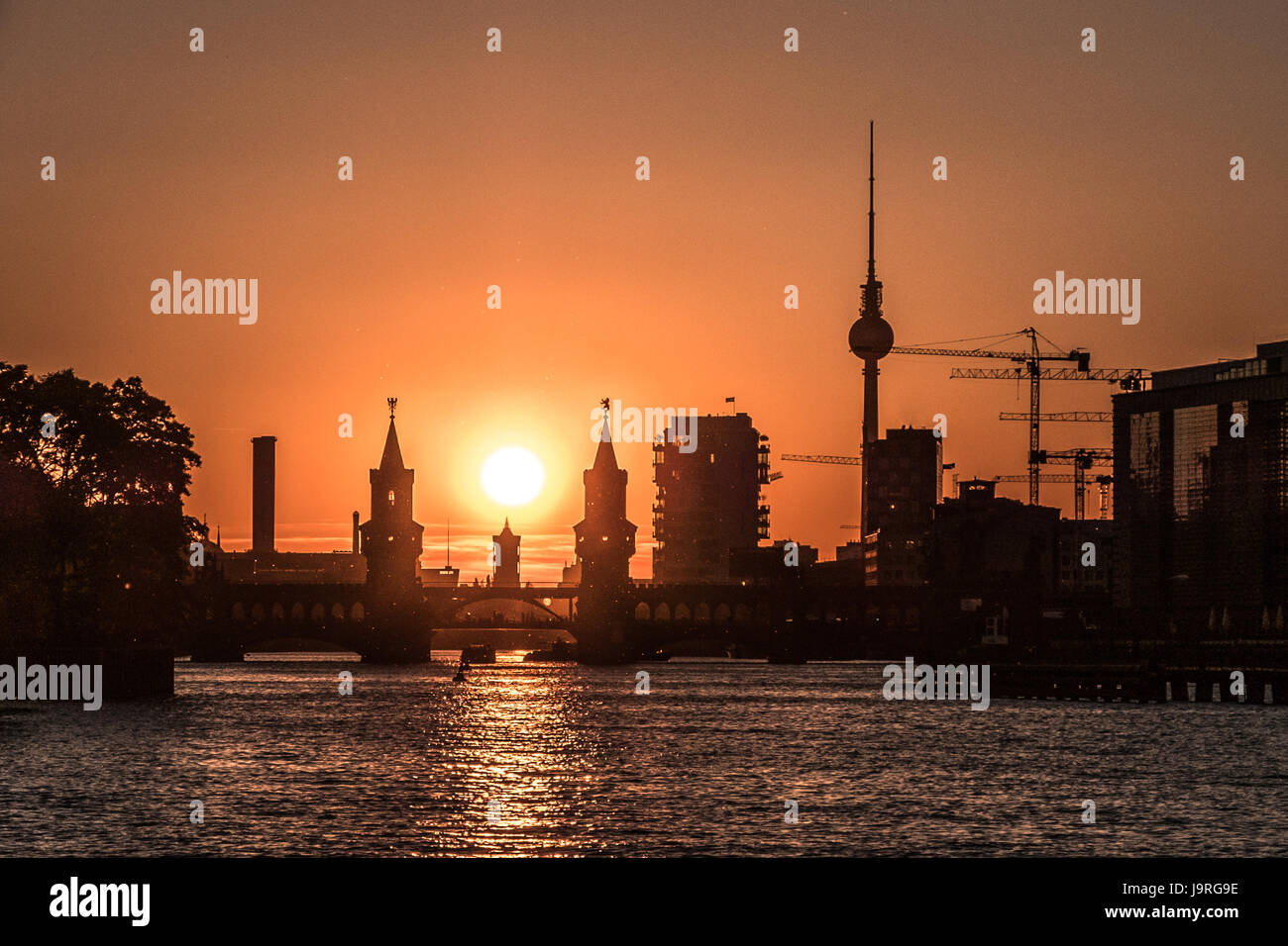 River Spree, Oberbaum Bridge, Tv Tower - Berlin city skyline with sunset sky Stock Photo