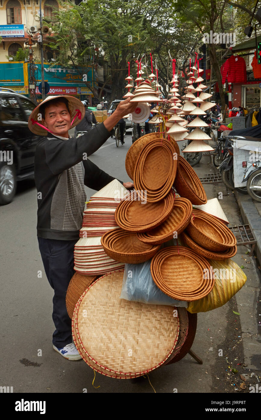 Steet vendor selling woven baskets and conical hats, Old Quarter, Hanoi, Vietnam Stock Photo