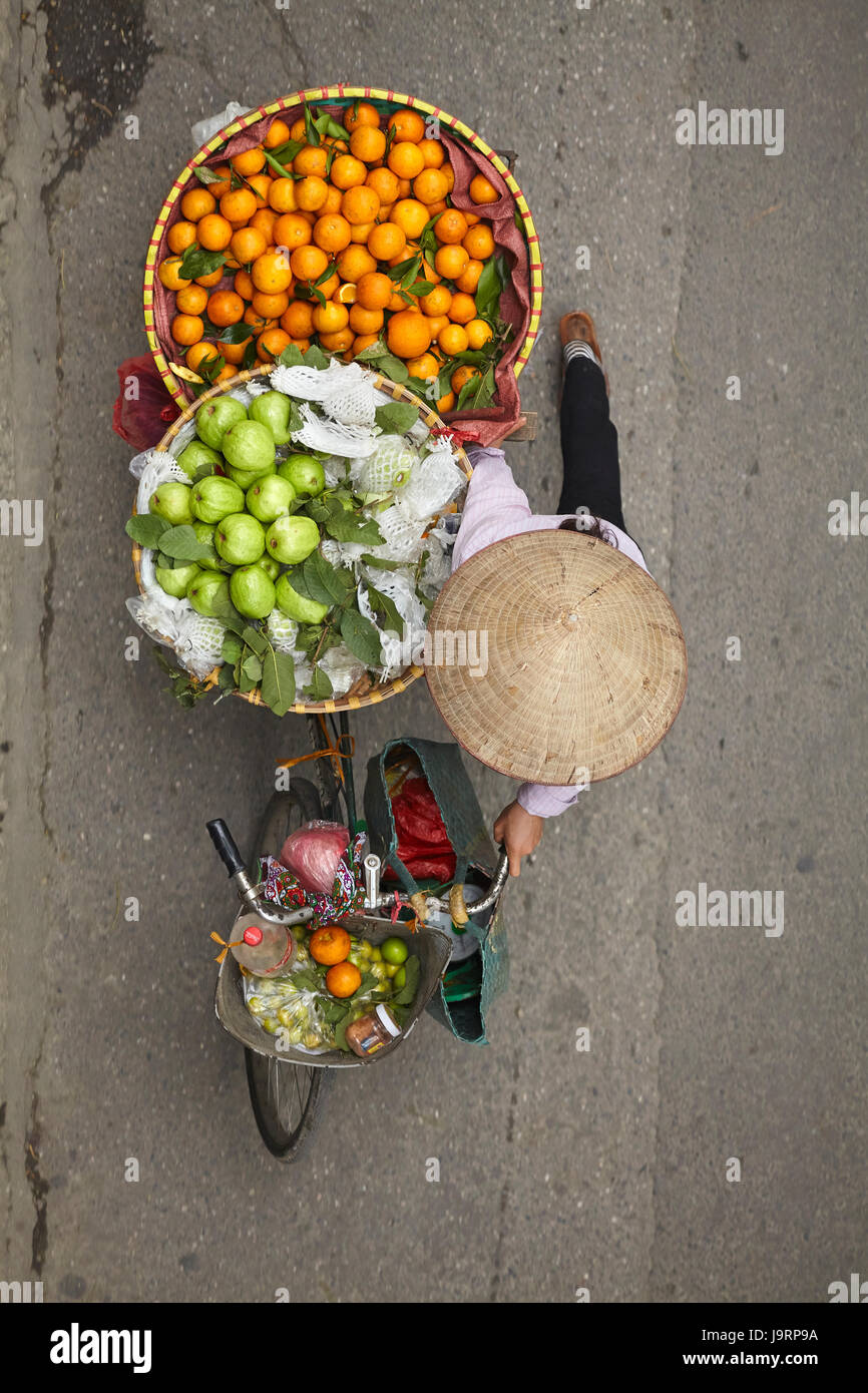 Street vendor with round baskets of fruit on bicycle, Old Quarter, Hanoi, Vietnam Stock Photo