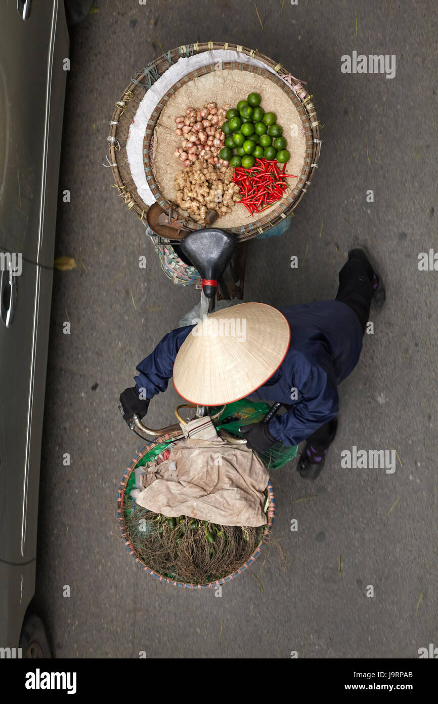 Street vendor with round baskets of fruit and vegetables on bicycle, Old Quarter, Hanoi, Vietnam Stock Photo