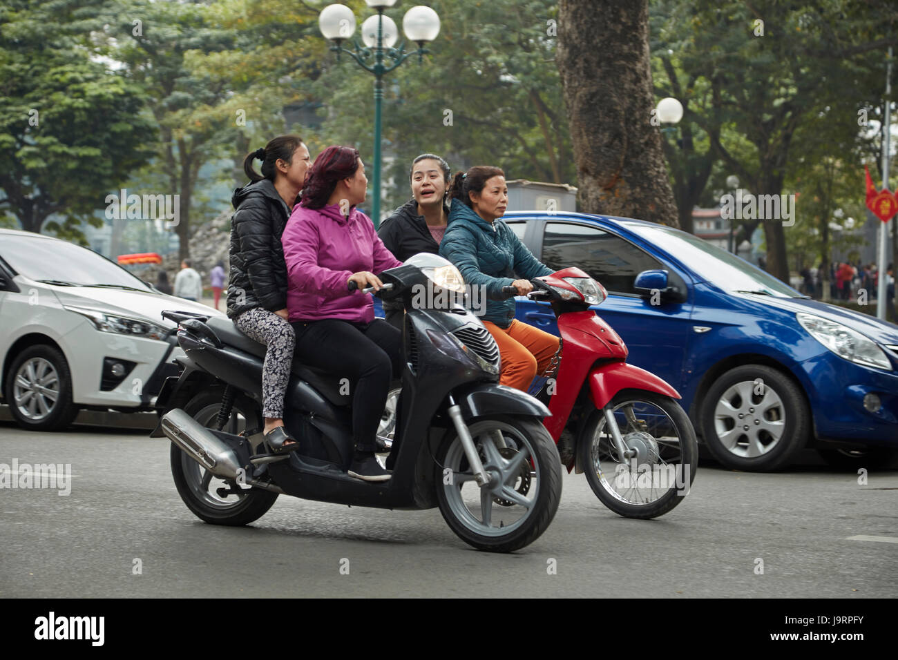 Women on scooters, Old Quarter, Hanoi, Vietnam Stock Photo