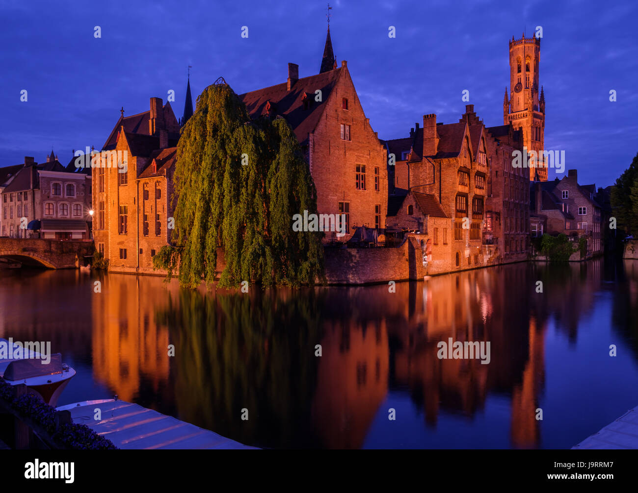 Bruges, Belgium. Famous photo spot 'Huidenvetters plein', with Dijver river canal during twilight and Belfort (Belfry) tower. Stock Photo
