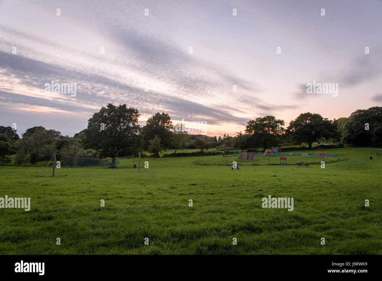 A moody sky with beautiful clouds at sunset in the evening across a field Stock Photo