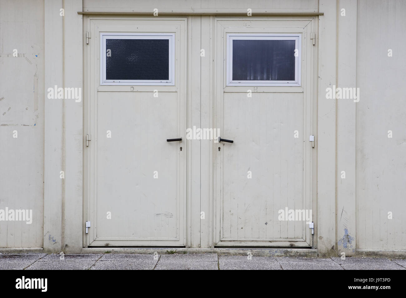 Factory building,doors,closed,building,old,white,facade,metal doors,iron doors,double door,input,exit,on the left,on the right,conception,choice,decision,access,closely,dreary,exited,architecture,detail,nobody,outside, Stock Photo