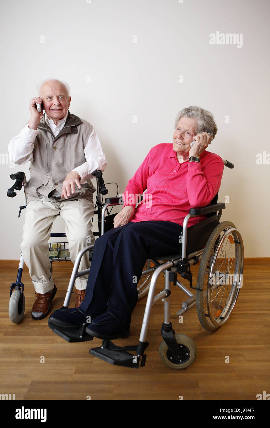 Senior citizen's couple,happily sit,invalid's wheel chair,walking help,mobile phones,call up,people,married couple,senior citizens,couple,old,happily,joy of living,actively,geriatric care,old care,cohesion,old age,partnership,old people's home,nursing home,disease,health,communication,telecommunication,telephone calls,inside,two, Stock Photo
