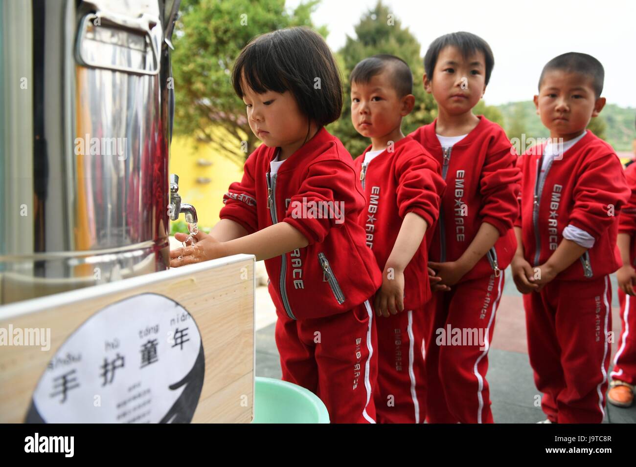 Huachi, China's Gansu Province. 3rd June, 2017. Children queue up to wash their hands at a kindergarten in Shangwan Village of Huachi County, northwest China's Gansu Province, June 3, 2017. To improve the hygiene education in remote areas, China Develpment Research Foundation and Unilever carried out a project to promote hand wash among children in classes. The project so far has covered more than 10,000 rural children in serveral provinces of China. Credit: Chen Bin/Xinhua/Alamy Live News Stock Photo