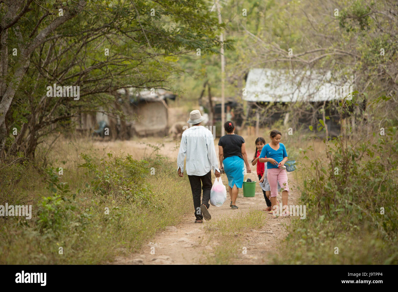 Villagers walk down a dusty road in El Sauce Municipality, Léon Department, Nicaragua. Stock Photo